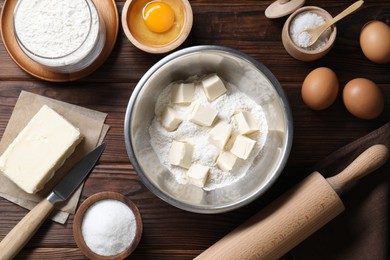 Photo of Making shortcrust pastry. Rolling pin, knife and different ingredients for dough on wooden table, flat lay