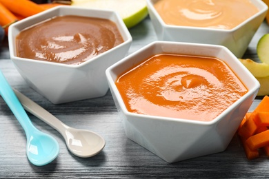 Photo of Healthy baby food and fresh ingredients on grey wooden table, closeup