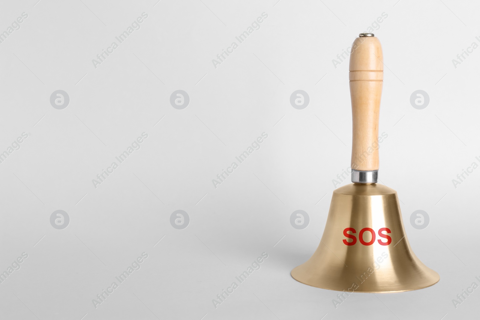 Image of Golden bell with wooden handle and abbreviation SOS on grey background. Space for text