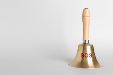 Image of Golden bell with wooden handle and abbreviation SOS on grey background. Space for text