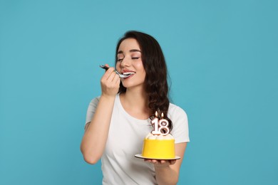 Photo of Coming of age party - 18th birthday. Woman tasting delicious cake with number shaped candles on light blue background