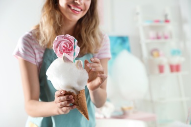 Young woman with cotton candy dessert indoors, closeup. Space for text