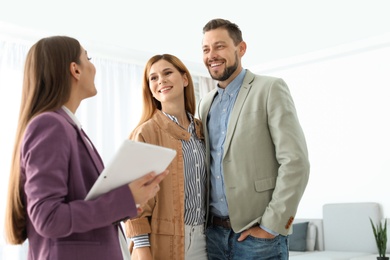 Female real estate agent working with couple in room