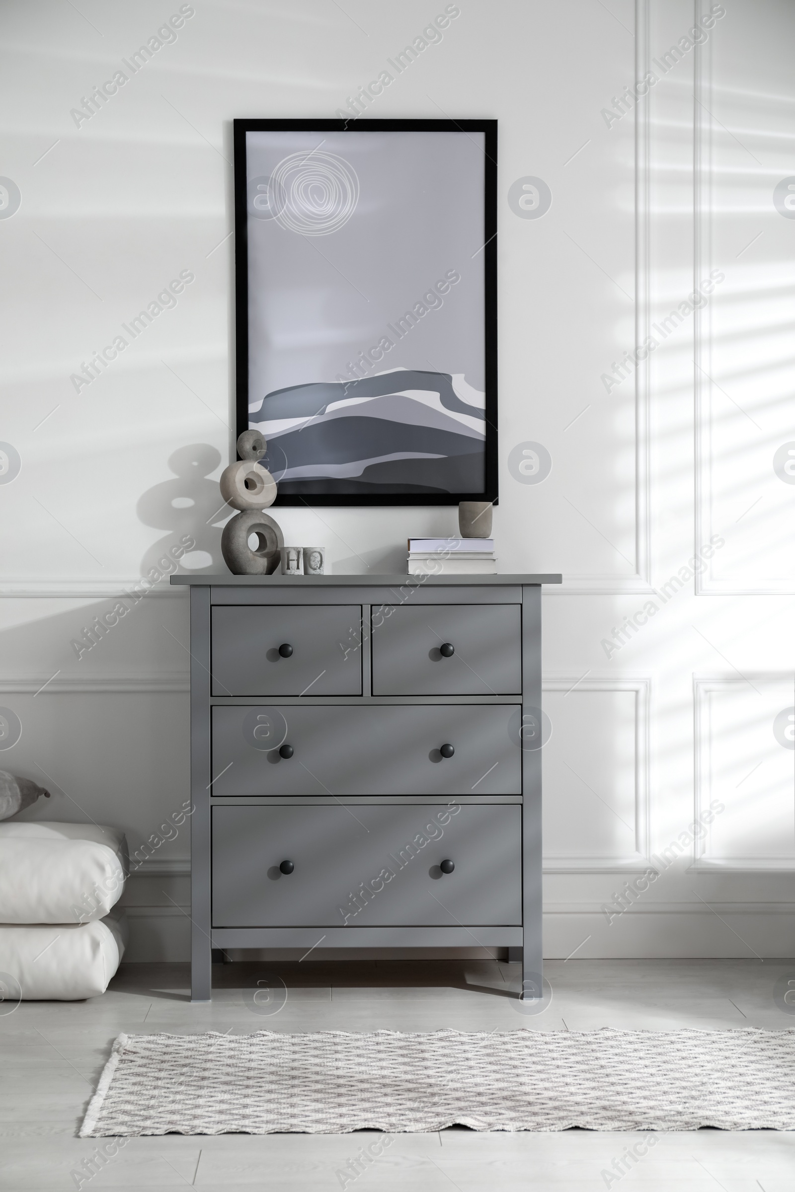 Photo of Stylish room interior with grey chest of drawers and beautiful picture