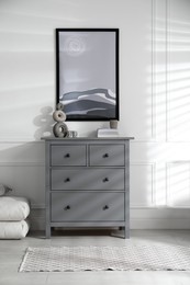Photo of Stylish room interior with grey chestdrawers and beautiful picture