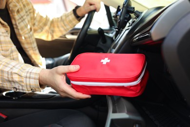 Photo of Man with first aid kit inside car, closeup