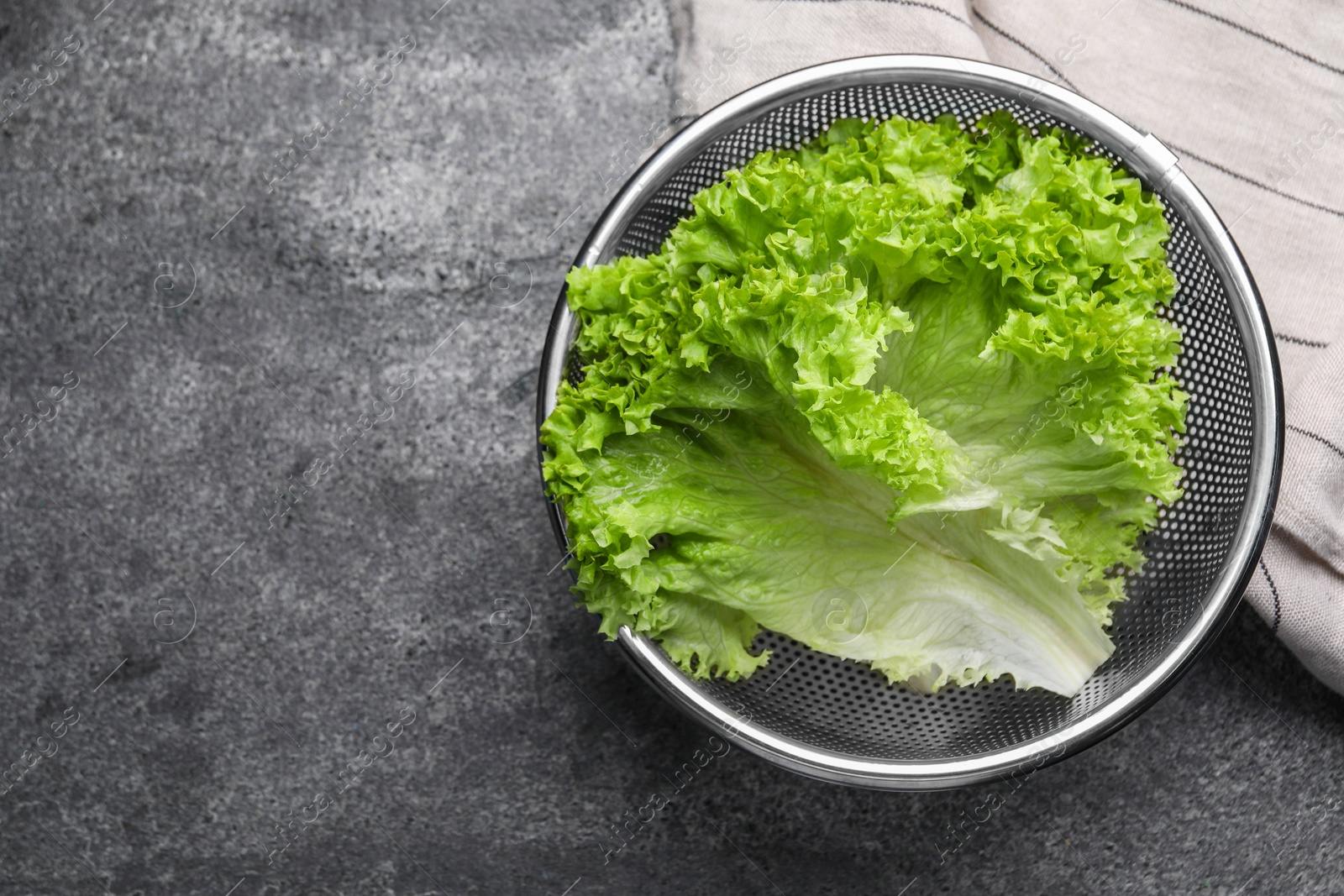 Photo of Fresh lettuce on stone table, top view. Space for text