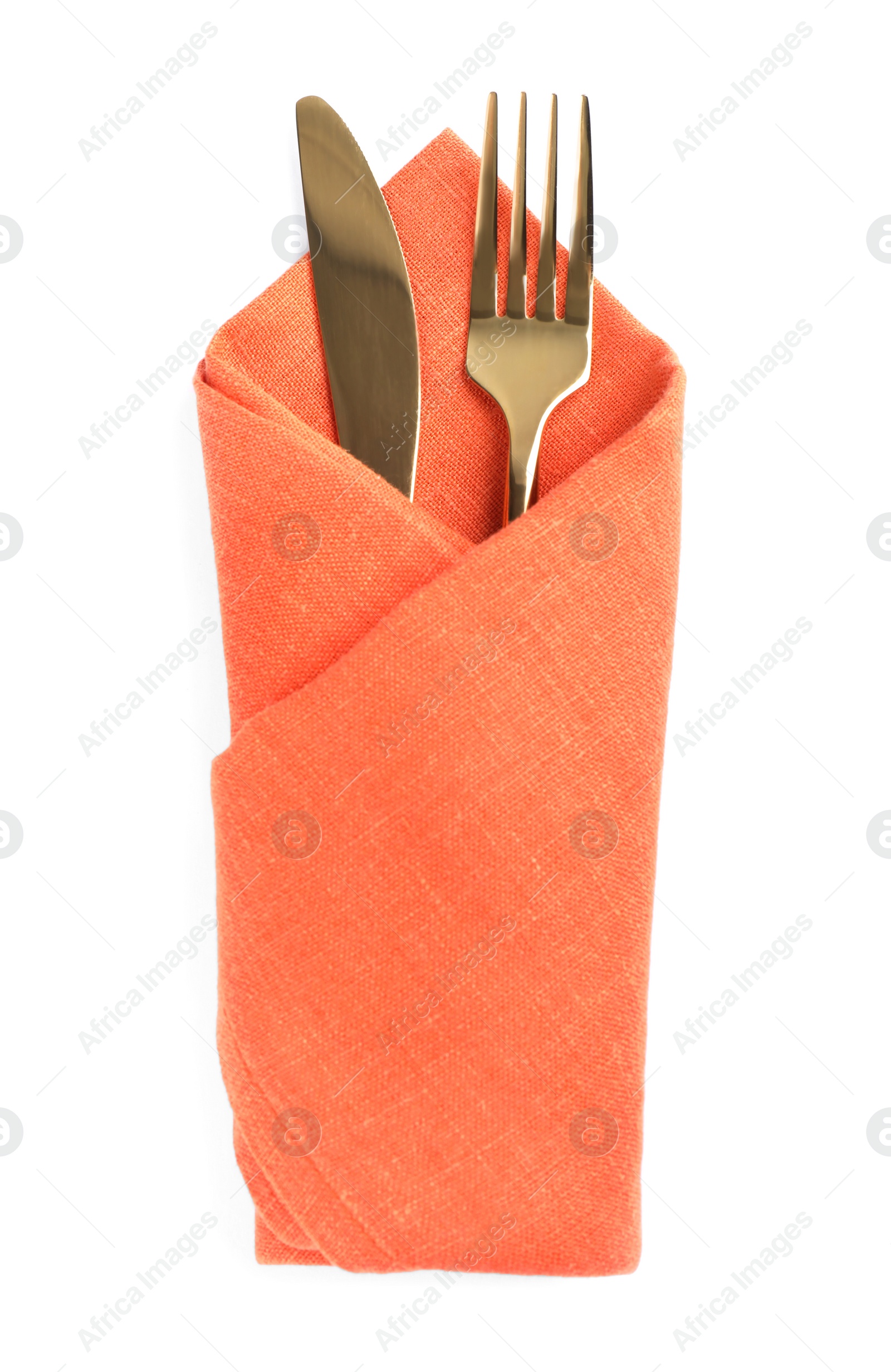 Photo of Golden fork and knife wrapped in orange napkin on white background, top view