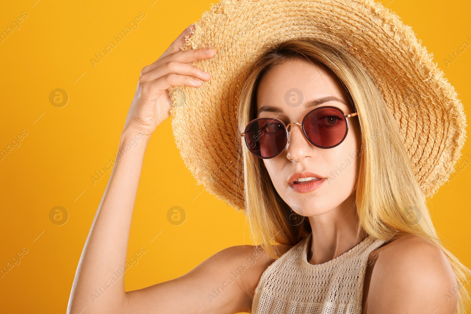 Photo of Beautiful woman in stylish sunglasses on yellow background