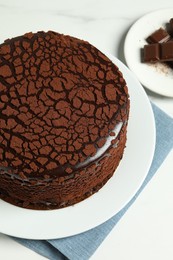 Delicious truffle cake and chocolate pieces on white marble table