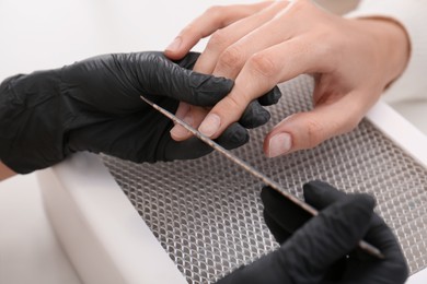 Photo of Professional manicurist working with client, closeup view