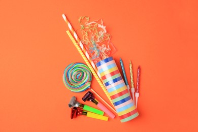 Photo of Party cracker and different festive items on orange background, flat lay. Space for text