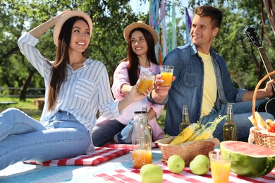 Photo of Young people enjoying picnic in park on summer day