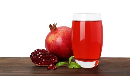 Photo of Refreshing pomegranate juice in glass, leaves and fruits on wooden table against white background