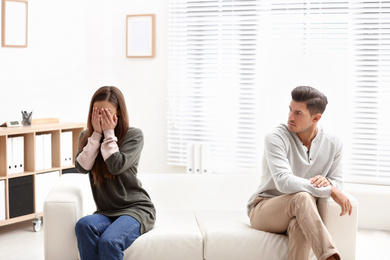 Photo of Emotional couple on sofa in psychologist's office