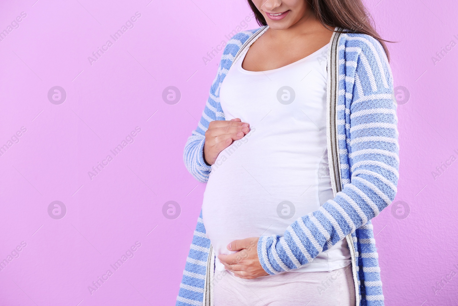 Photo of Pregnant woman posing on color background, closeup. Space for text