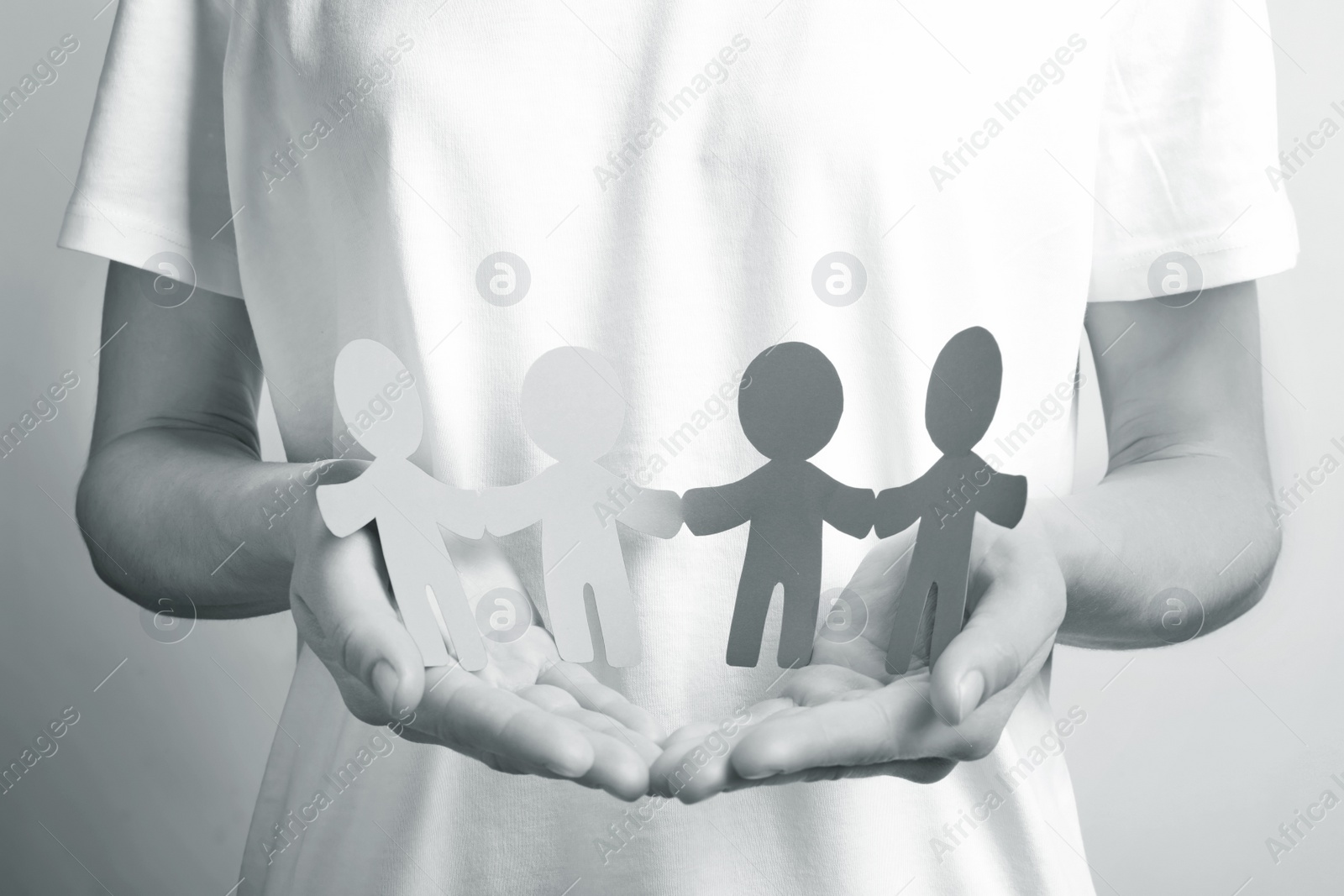 Image of Young woman holding paper people, closeup. Unity concept