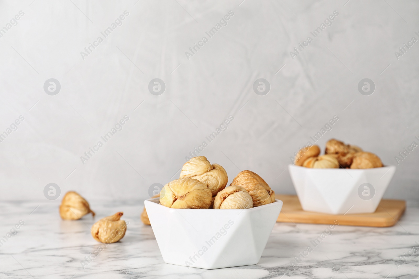 Photo of Bowl with dried figs on marble table, space for text. Healthy fruit