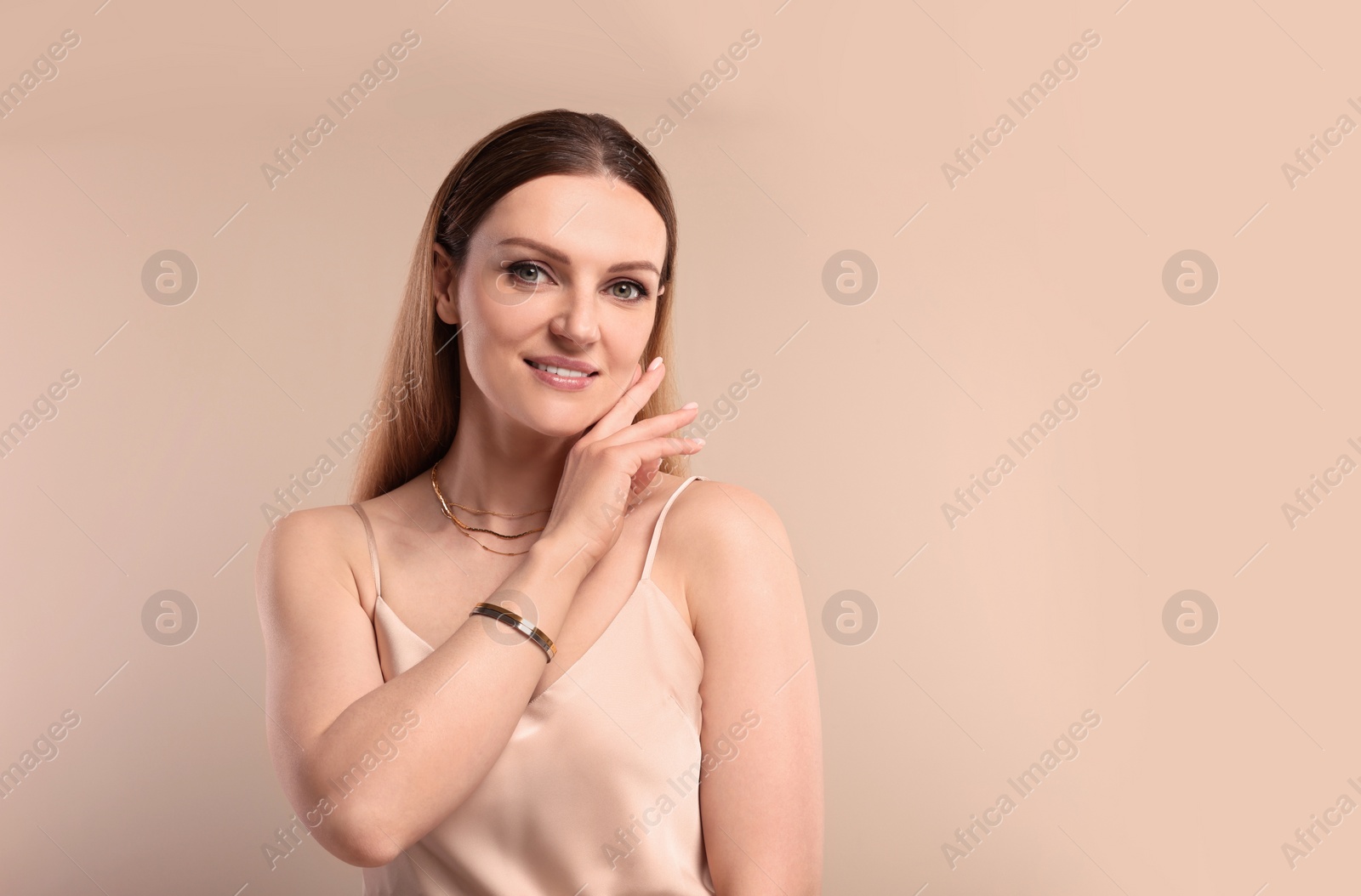 Photo of Beautiful woman with elegant jewelry on beige background