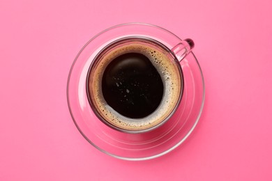 Photo of Fresh coffee in cup on pink background, top view