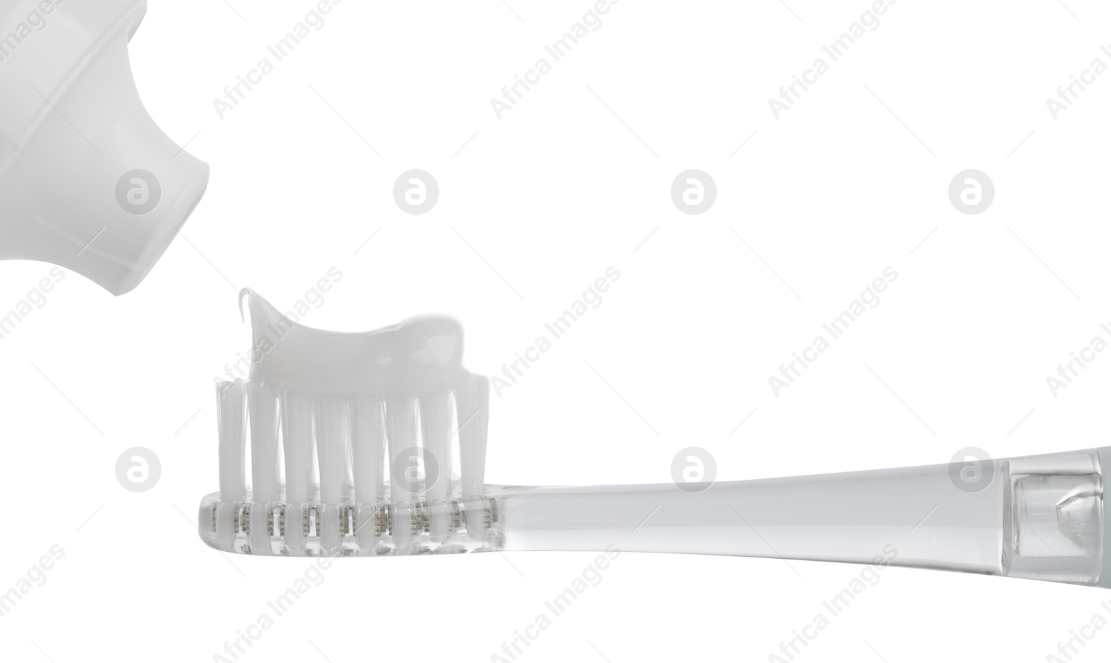 Photo of Applying paste on electric toothbrush against white background, closeup