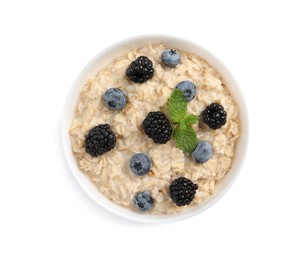 Photo of Tasty oatmeal porridge with blackberries and blueberries in bowl on white background, top view
