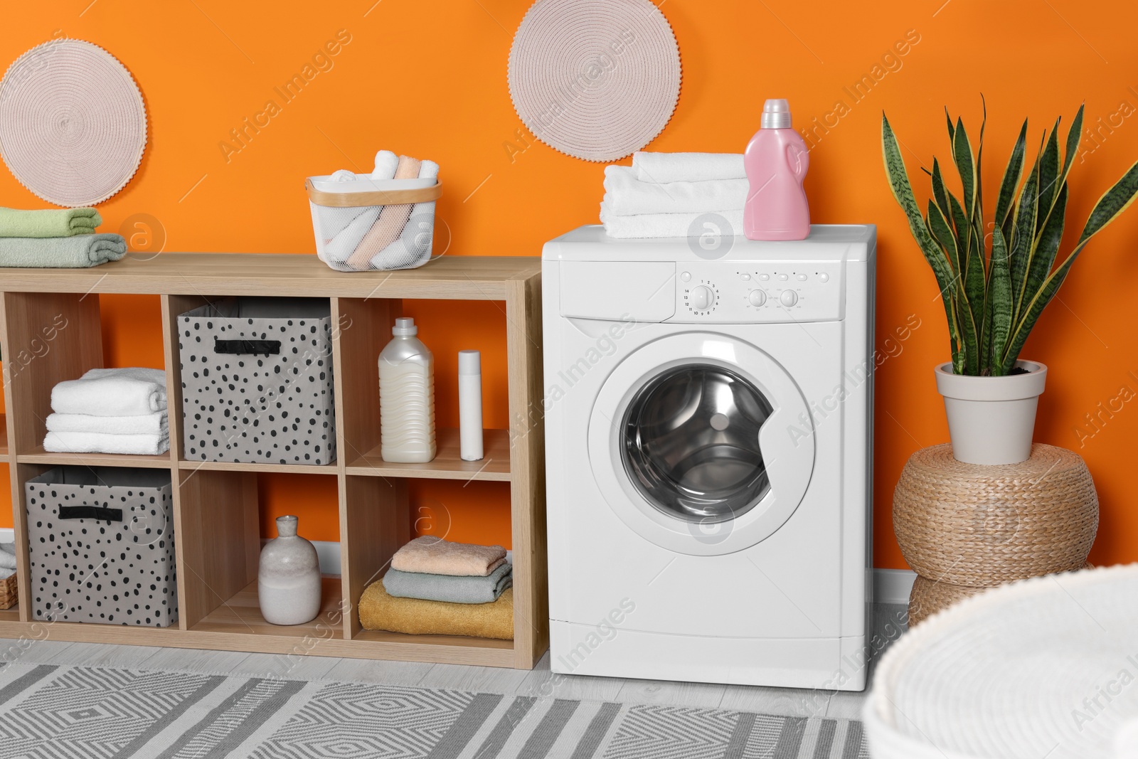 Photo of Stylish laundry room with washing machine. Interior design