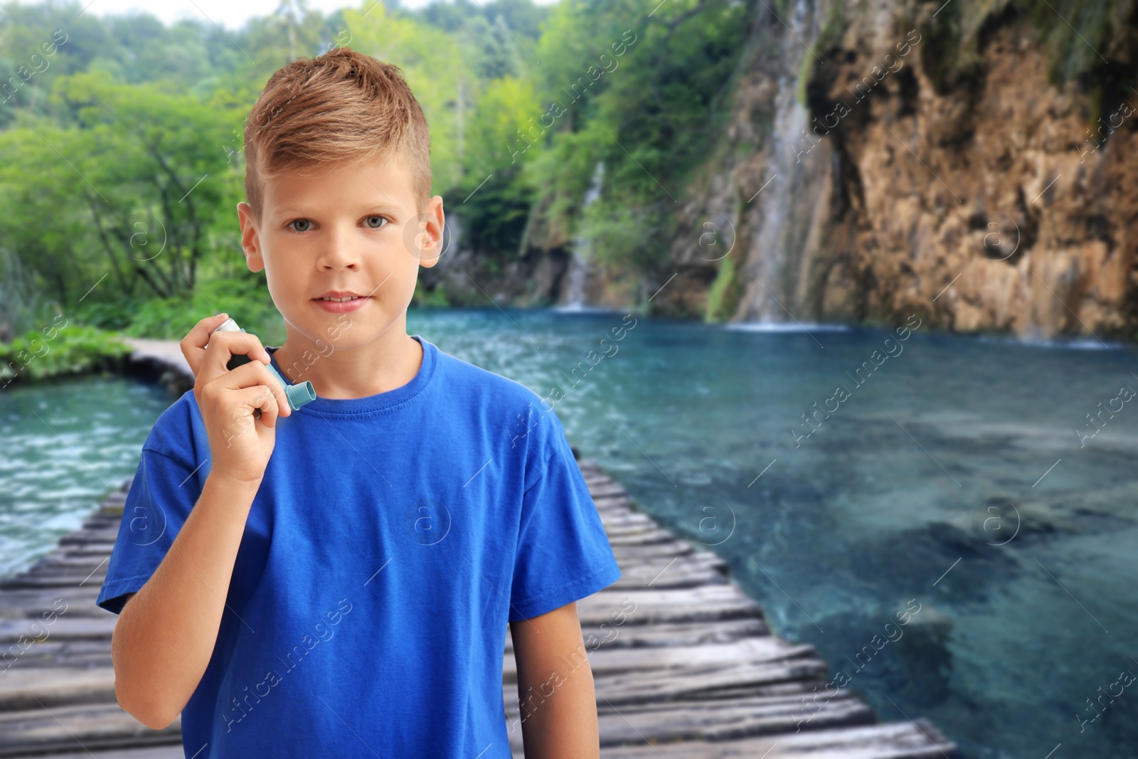 Image of Little boy with asthma inhaler outside on sunny day. Emergency first aid during outdoor recreation