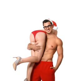 Photo of Attractive young Santa Claus with sexy woman on white background