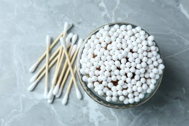 Photo of Many cotton buds on light grey marble table, flat lay