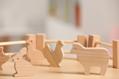 Wooden animals and fence on table, closeup. Children's toys