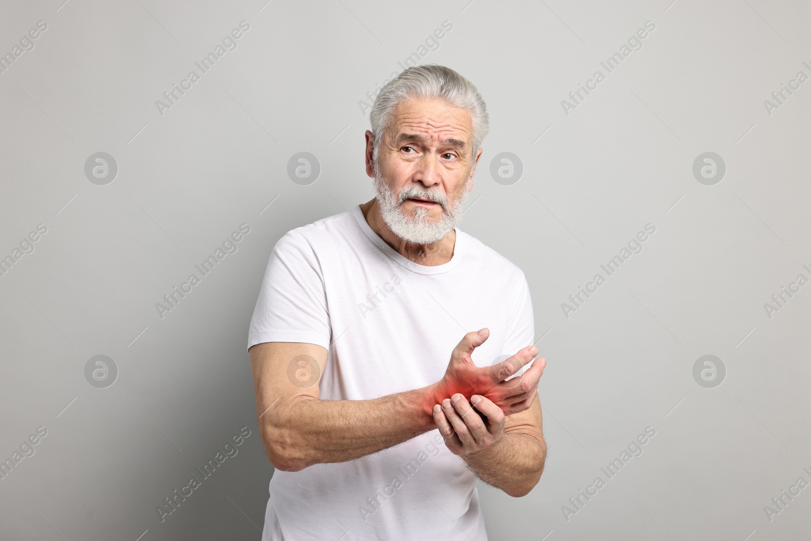 Image of Senior man suffering from pain in wrist on grey background