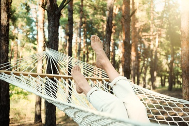 Photo of Woman resting in hammock outdoors on summer day, closeup of legs