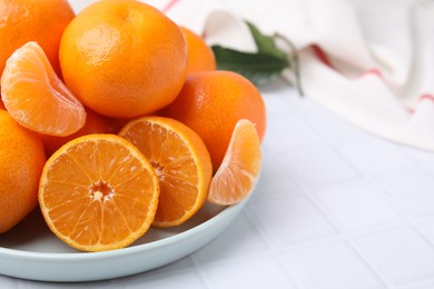 Fresh juicy tangerines on white tiled table, space for text