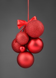 Photo of Beautiful red Christmas balls with bow on grey background