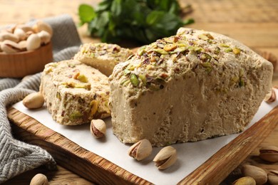 Photo of Tasty halva with pistachios on table, closeup