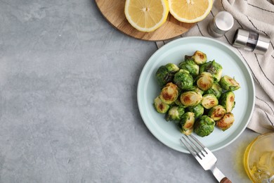 Photo of Delicious roasted Brussels sprouts served on grey table, top view. Space for text