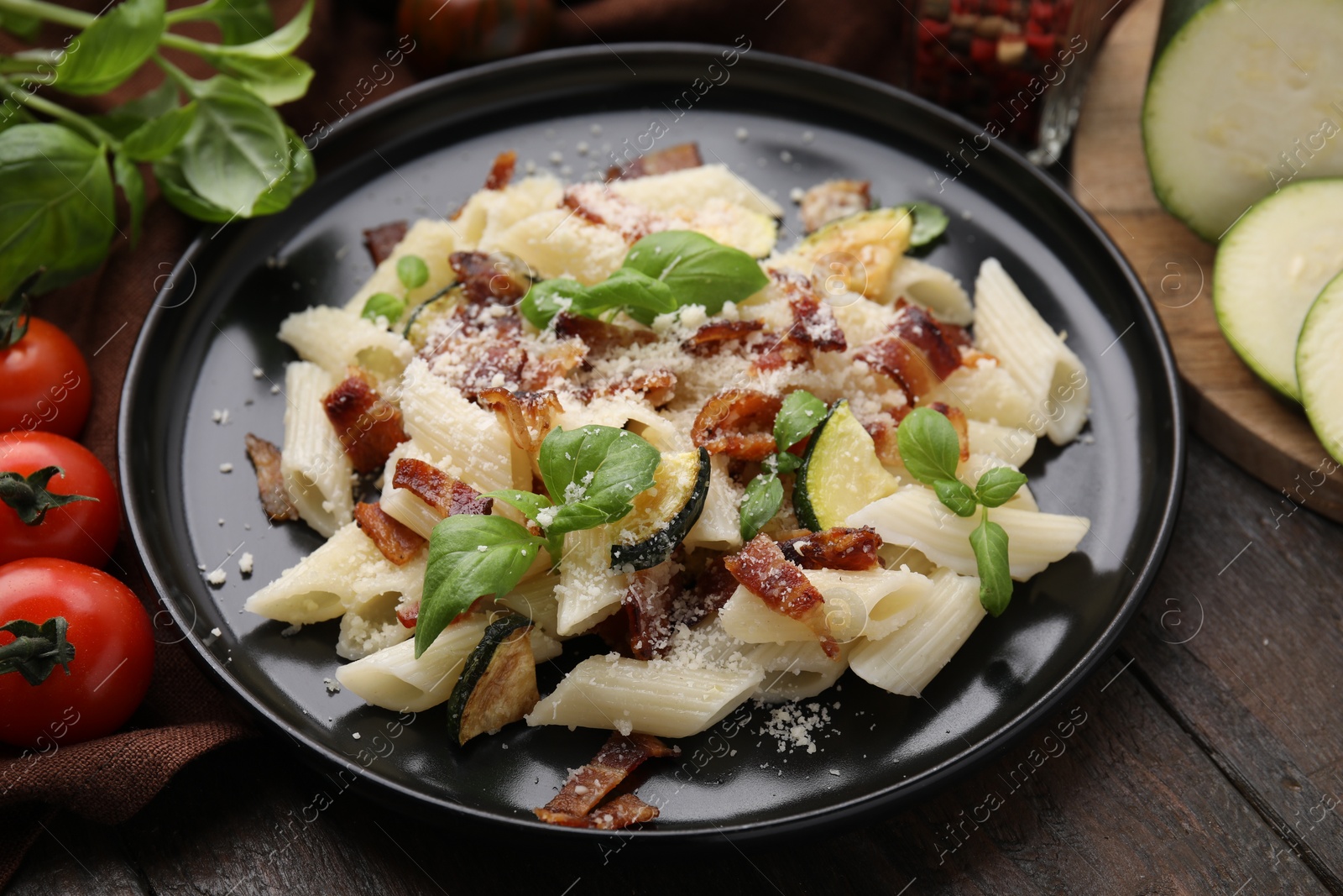 Photo of Tasty pasta with bacon and basil on wooden table