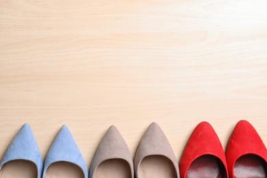Photo of Flat lay composition of stylish lady's shoes on wooden background, space for text