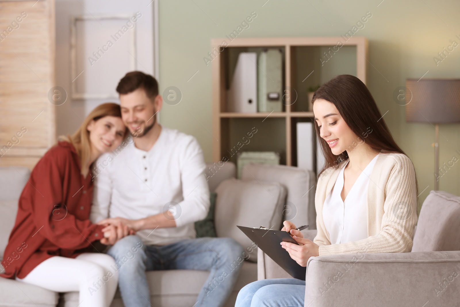 Photo of Professional psychologist and young couple in office