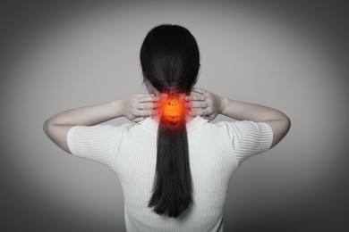 Arthritis symptoms. Young woman suffering from pain in neck on light grey background, back view