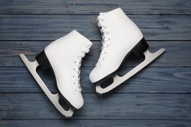 Pair of skates on dark blue wooden background, flat lay