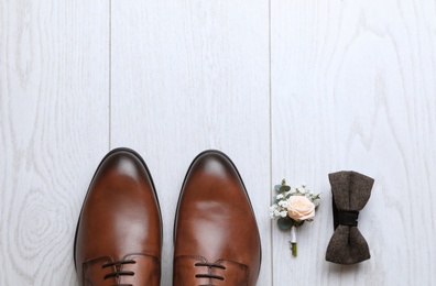 Photo of Flat lay composition with wedding shoes on white wooden floor, space for text