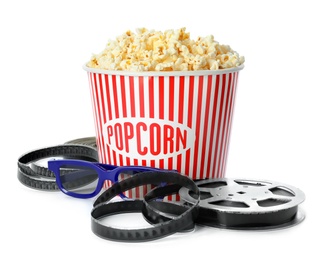 Bucket of fresh popcorn and movie reel on white background. Cinema snack