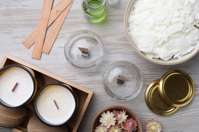 Photo of Flat lay composition with homemade candles and ingredients on light wooden background