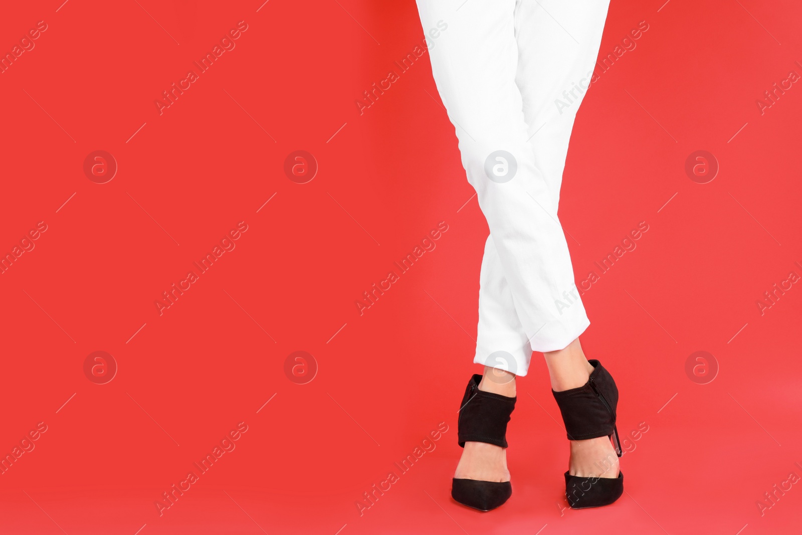 Photo of Woman in elegant shoes on red background. Space for text