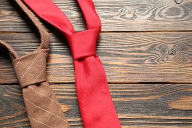 Photo of Two neckties on wooden table, top view. Space for text