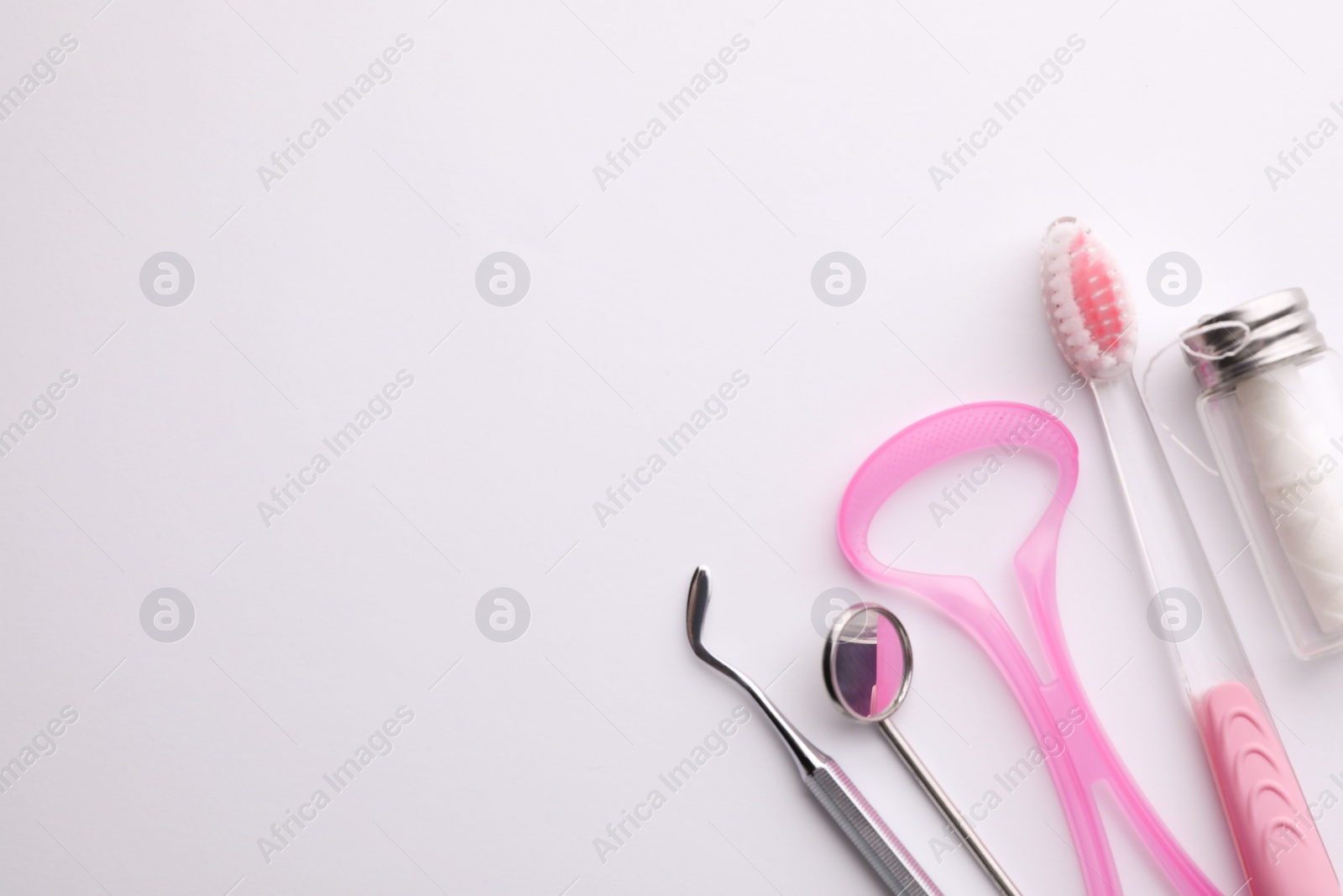 Photo of New tongue cleaner and teeth care products on white background, top view