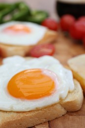 Tasty toasts with fried egg on wooden table, closeup