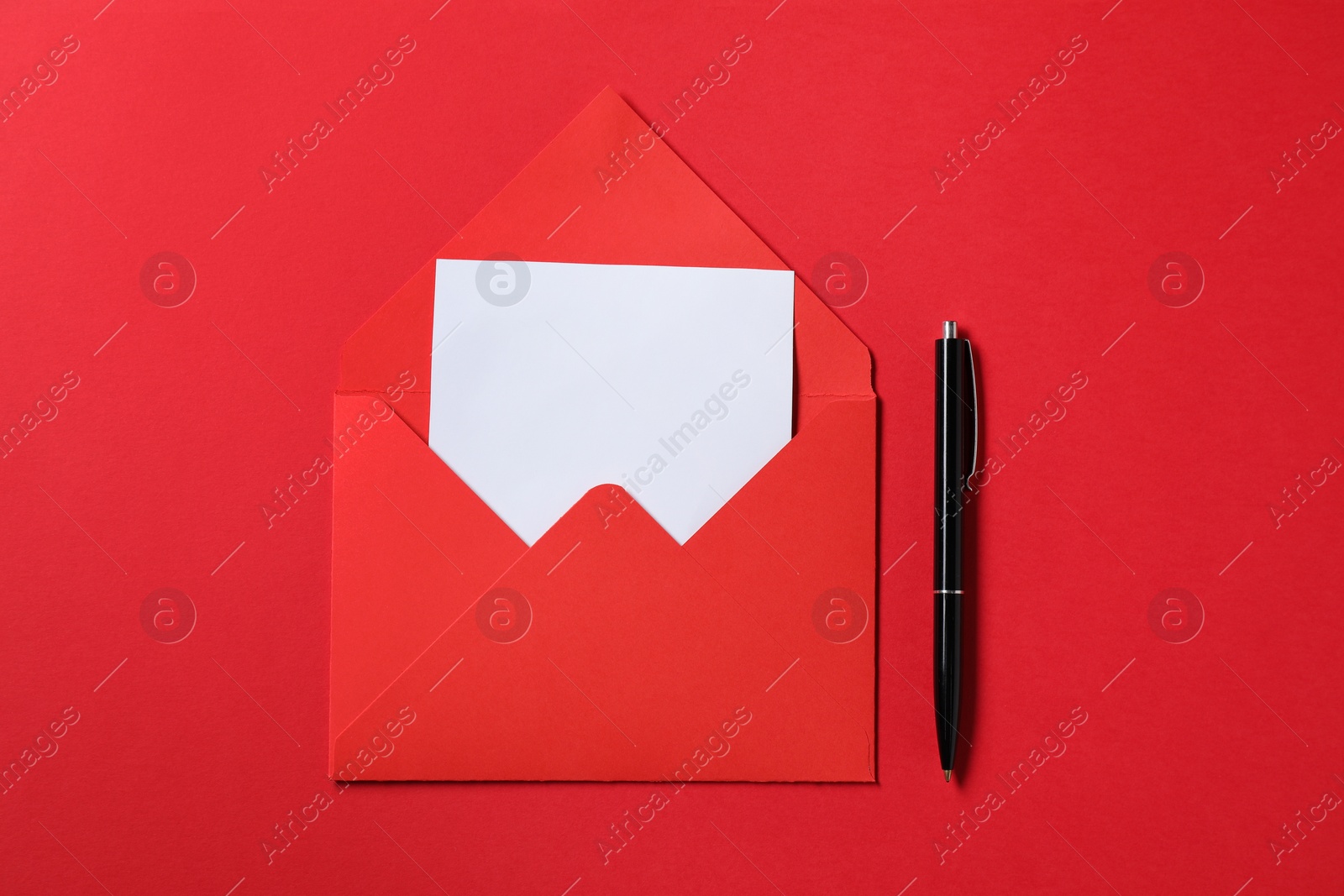 Photo of Blank sheet of paper, letter envelope and pen on red background, top view. Space for text